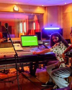 Multiracial musicians and technician in a music studio, recording session.