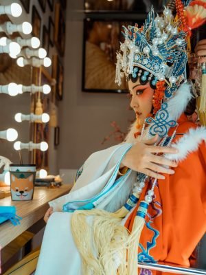 Side view of chinese actress in her cultural outfit sitting besi